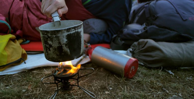 female hiker cooking outdoors