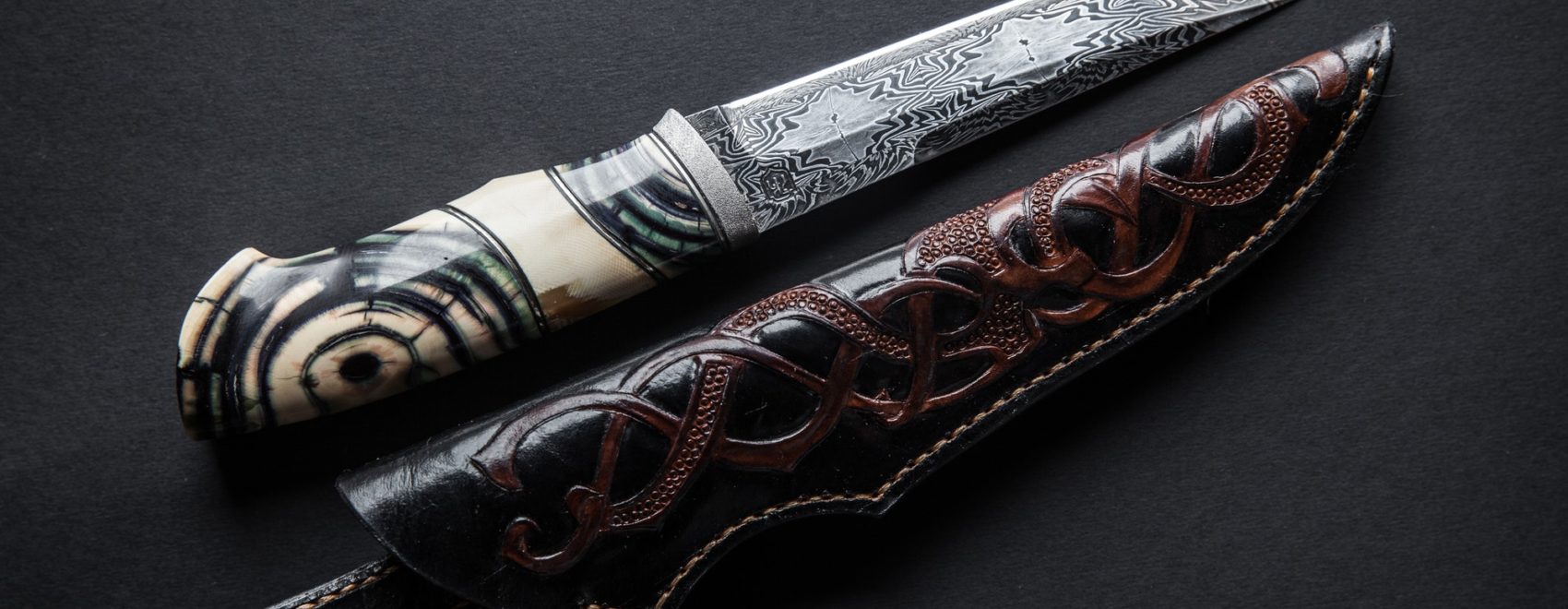 Hunter knife with wooden handle on a dark background