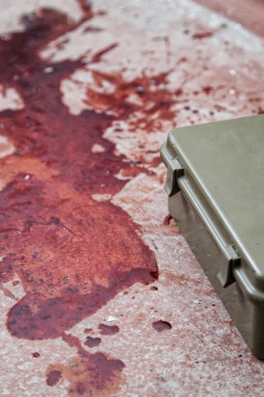 Military firs aid kit on floor with blood stains